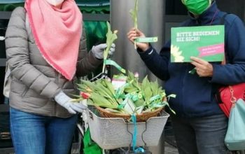 Zwei Grüne verteilen Blumen